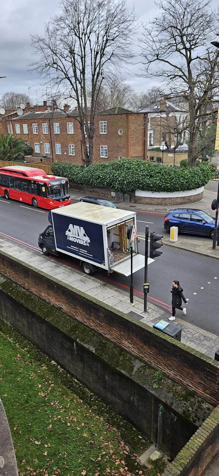 MV Movers removals van on a London street with a red bus